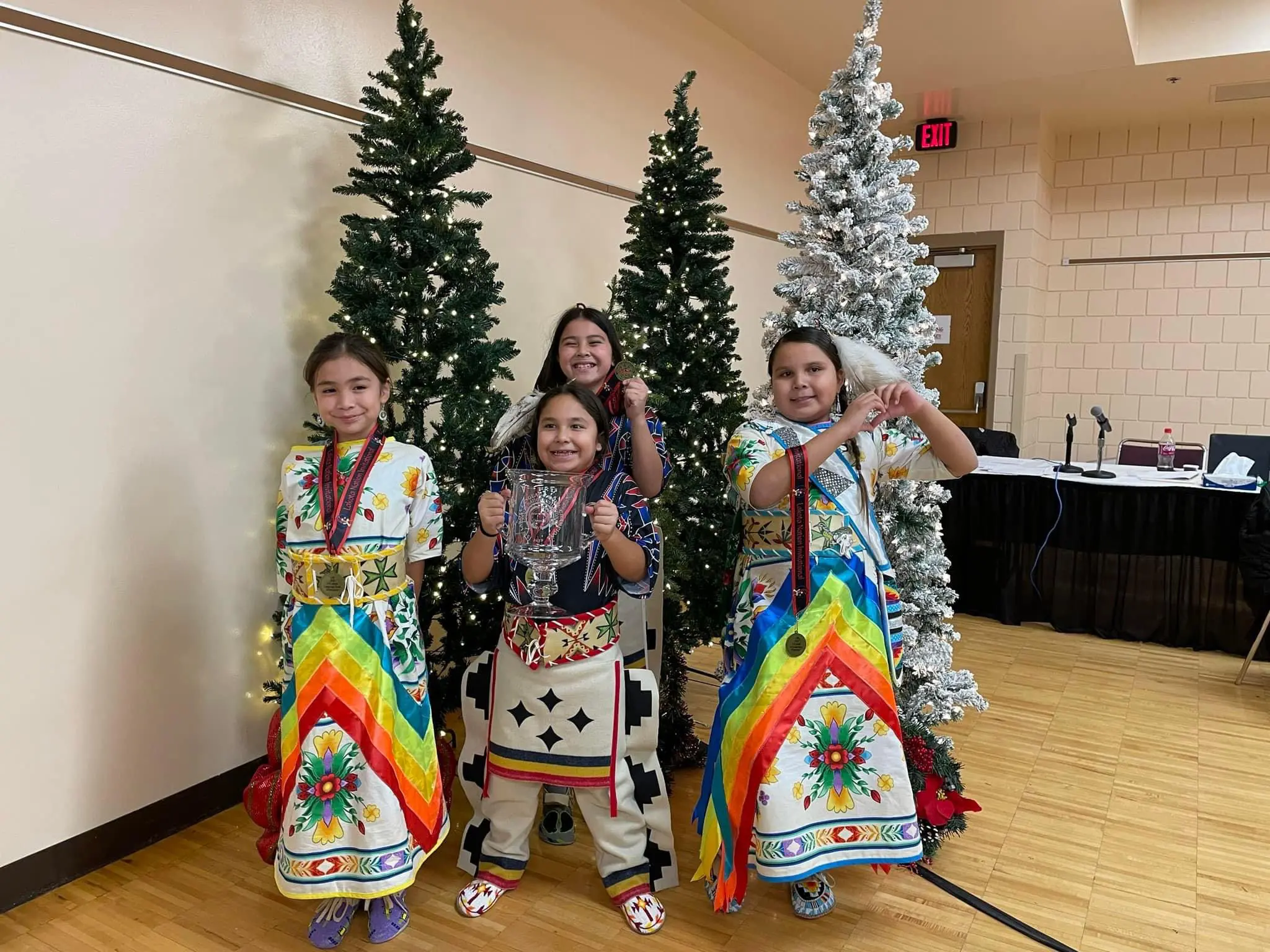 Full attire children holding a trophy